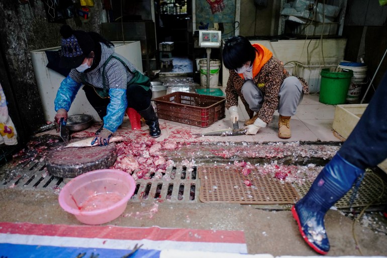Fish vendors prepare fish for sale at a wet market almost a year after the global outbreak of the coronavirus disease (COVID-19) in Wuhan, Hubei province, China December 7, 2020. Picture taken December 7, 2020. REUTERS/Aly Song