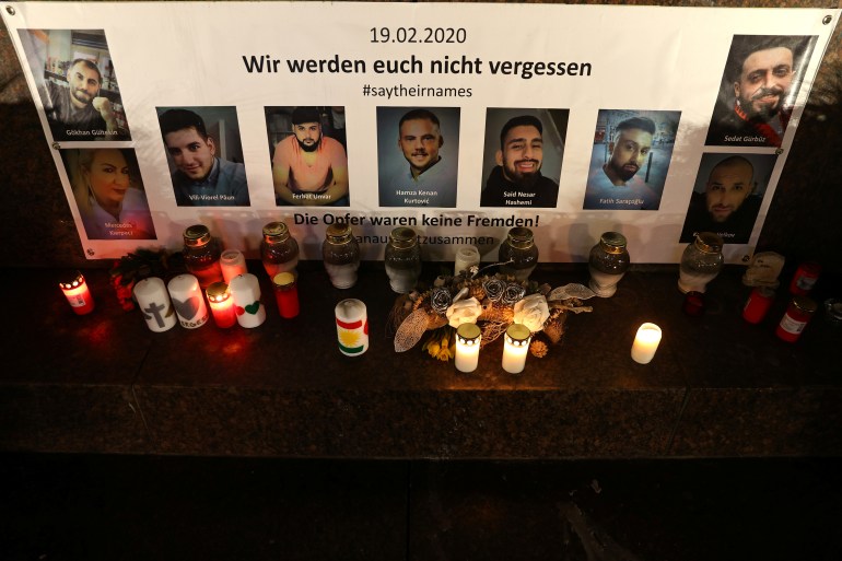 Pictures of the victims and candles are seen at the statue of German writers brothers Grimm one night ahead of the first anniversary of an attack where a man, who had posted a racist manifesto online, shot dead nine people in Hanau, Germany, February 18, 2021. REUTERS/Kai Pfaffenbach