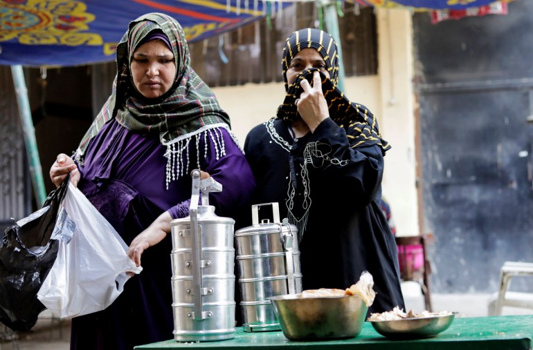 Women take prepared food to eat during Iftar