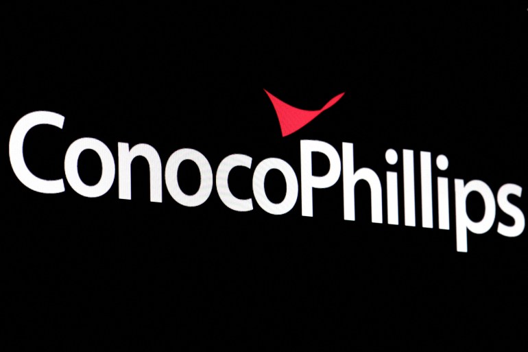A screen displays the logo for ConocoPhillips on the floor of the New York Stock Exchange