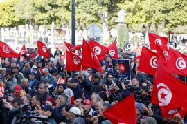 Supporters of Tunisia's Salvation Front opposition wave flags during a protest over the arrest of some of its leaders and other prominent critics of the president, in Tunis