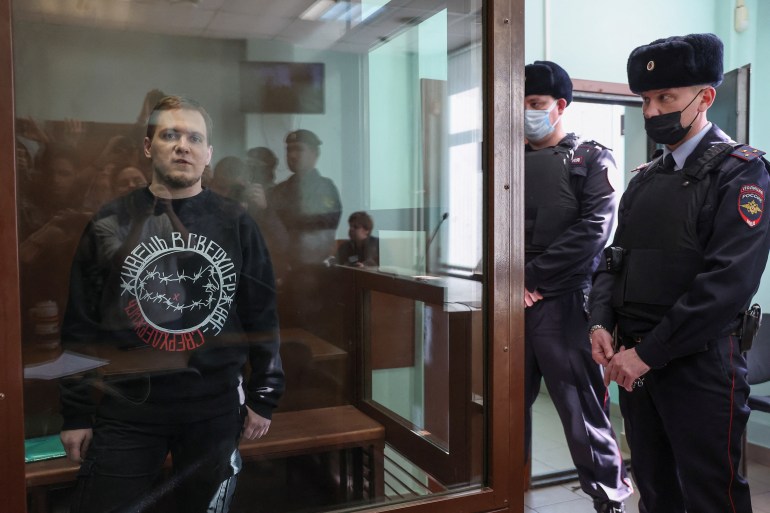 Russian opposition activist Dmitry Ivanov, accused of spreading false information about the Russian army in the course of Russia-Ukraine military conflict, stands inside an enclosure for defendants as he attends a court hearing in Moscow, Russia, March 7, 2023. REUTERS/Stringer