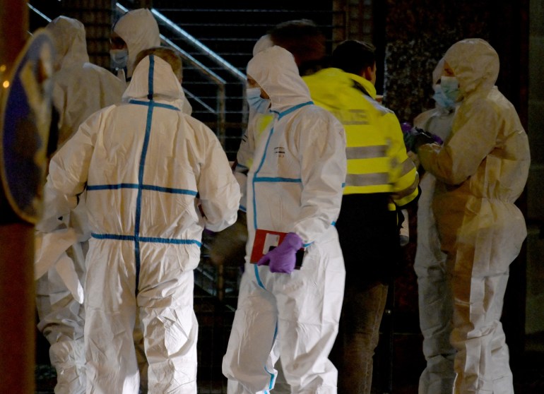 Forensic experts in hazmat suits at the scene
