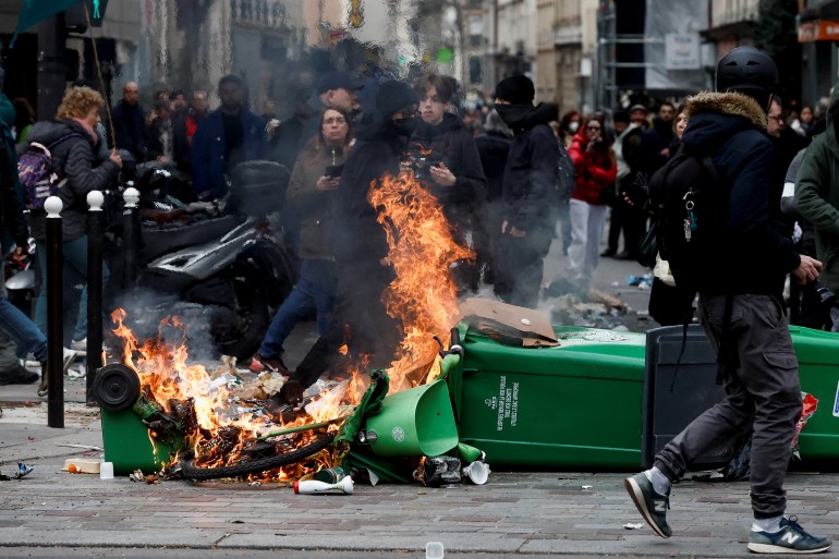 Rubbish bins set on fire as French unions rally against pensions reforms in Paris, France.