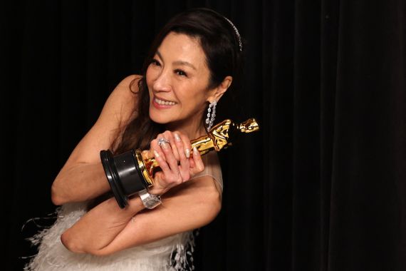 Michelle Yeoh holds her trophy up high