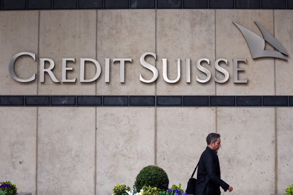 A person walks past the Credit Suisse office in Canary Wharf in London