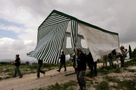 Israeli activists carry a tent in the abandoned Jewish settlement of Homesh, in the northern West Bank, March 27, 2007.