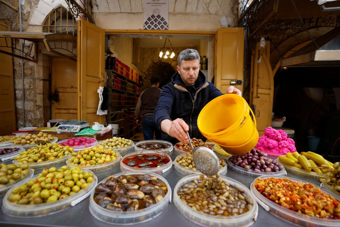 A Palestinian vendor arranges food items at a Palestinian shop ahead of Ramadan in Hebron in the Israeli-occupied West Bank