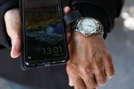 A watch and a phone on display, both showing the time.