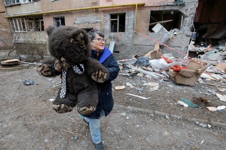 A local resident carries a teddy bear