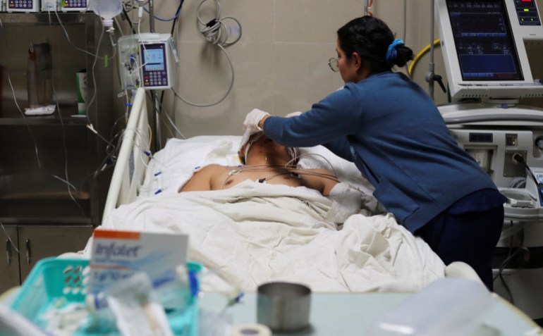 A nurse takes care of a migrant who is one of the victims of a fire that broke out late on Monday at a migrant detention center, at Hospital General of Ciudad Juarez