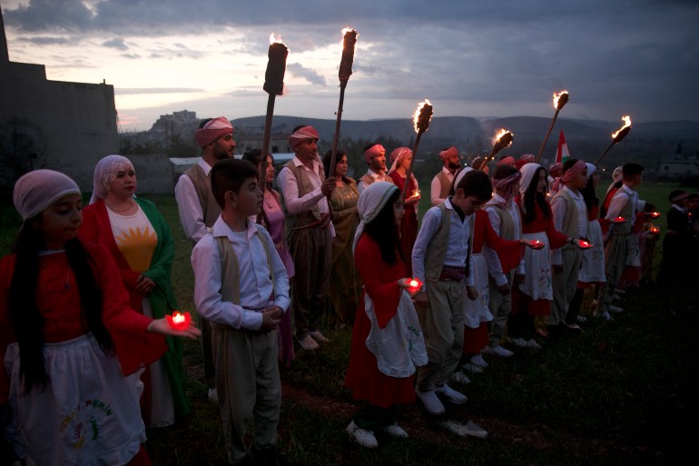 A row of people holding flaming torches