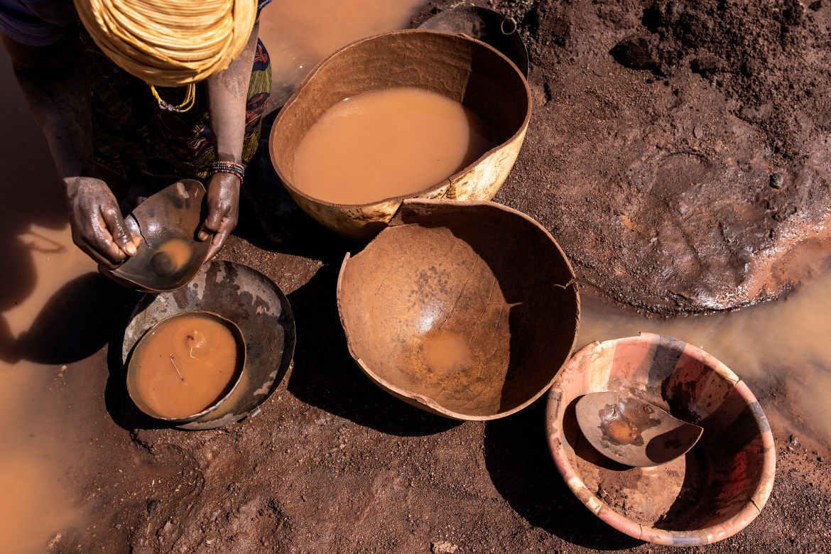 An artisanal miner pans for gold at the Karakaene gold mine