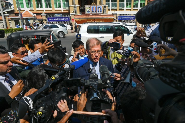 US Ambassador W Patrick Murphy speaking to the media outside the Phnom Penh Municipal Court. He is surrounded by a large group of reporters some with microphones