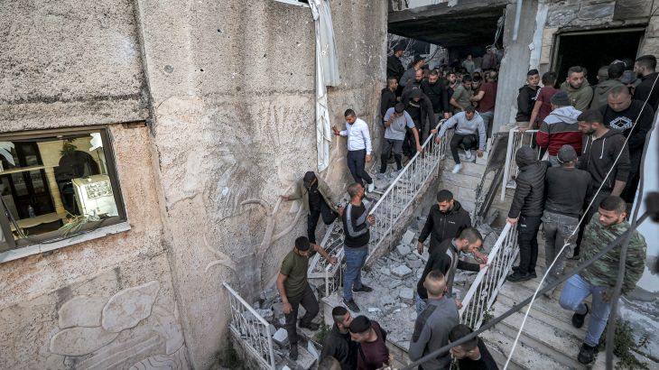 People inspect the wreckage of a building