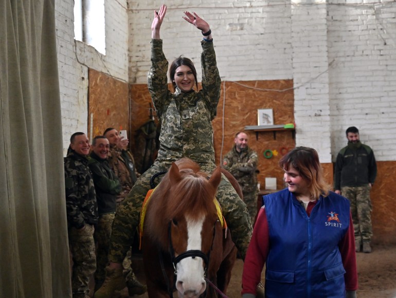 A Ukrainian servicewoman rides a horse during a hippotherapy session in Kyiv