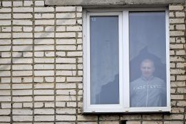 Alexei Moskalyov, 54, looks out of his flat after he was placed under house arrest in Yefremov [File: Natalia Kolesnikova]
