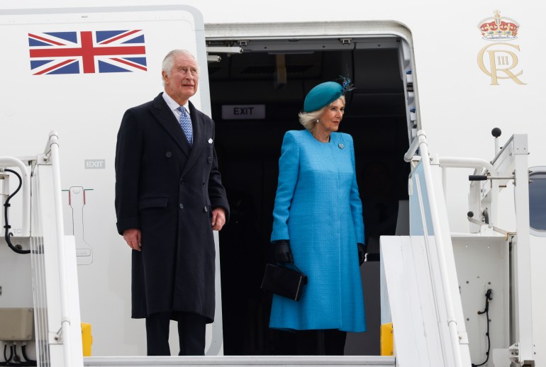 Britain's King Charles III (L) and Britain's Camilla, Queen Consort get off their plane