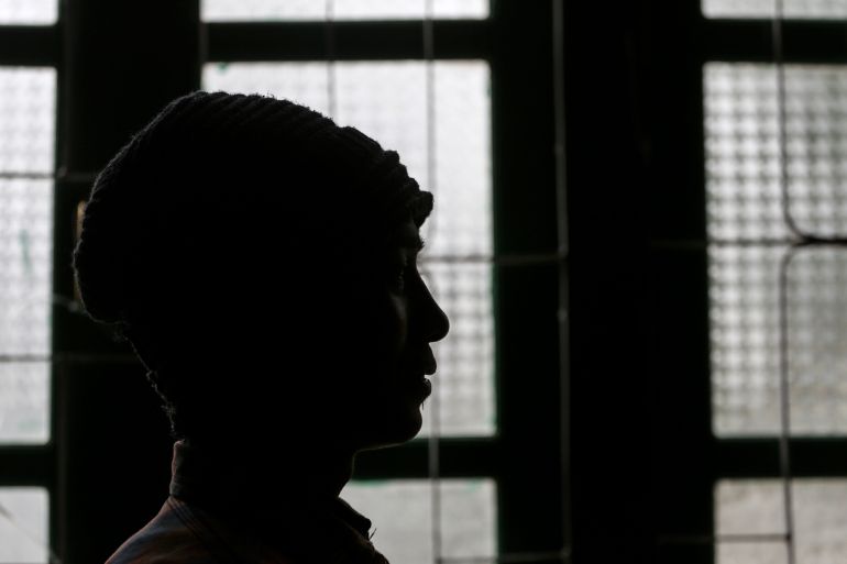 A picture of Aung Pyae in profile silhouetted against a window. He is wearing a woolly hat.