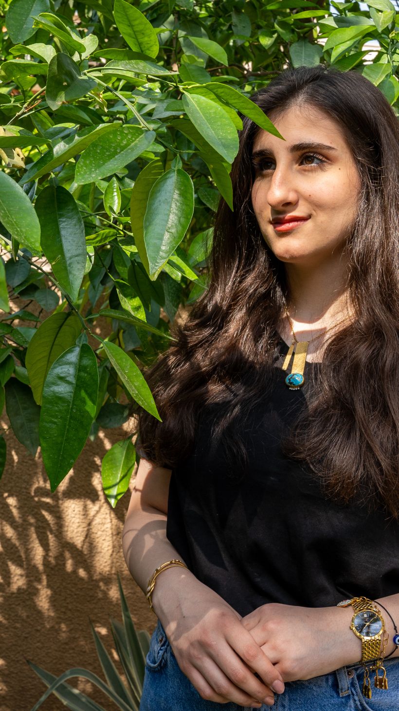 A photo of Mayar standing next to a tree.