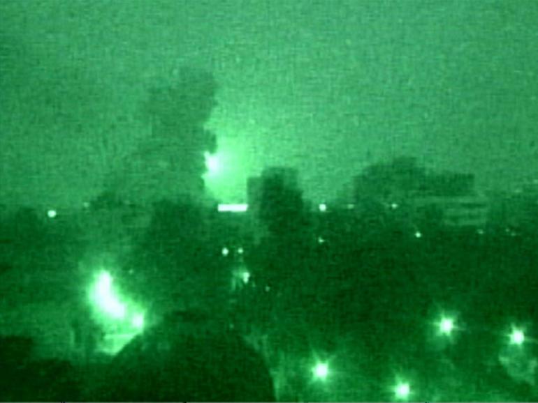 Smoke rises from a missile strike in a night-vision photo