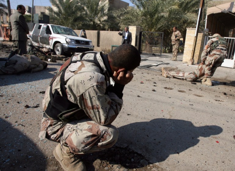 Iraqi Army soldiers are seen moments after a suicide attack in the Karradah neighbourhood of central Baghdad