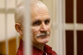 Ales Bialiatski, the head of Belarusian Vyasna rights group, stands in a defendants' cage during a court session in Minsk, Belarus