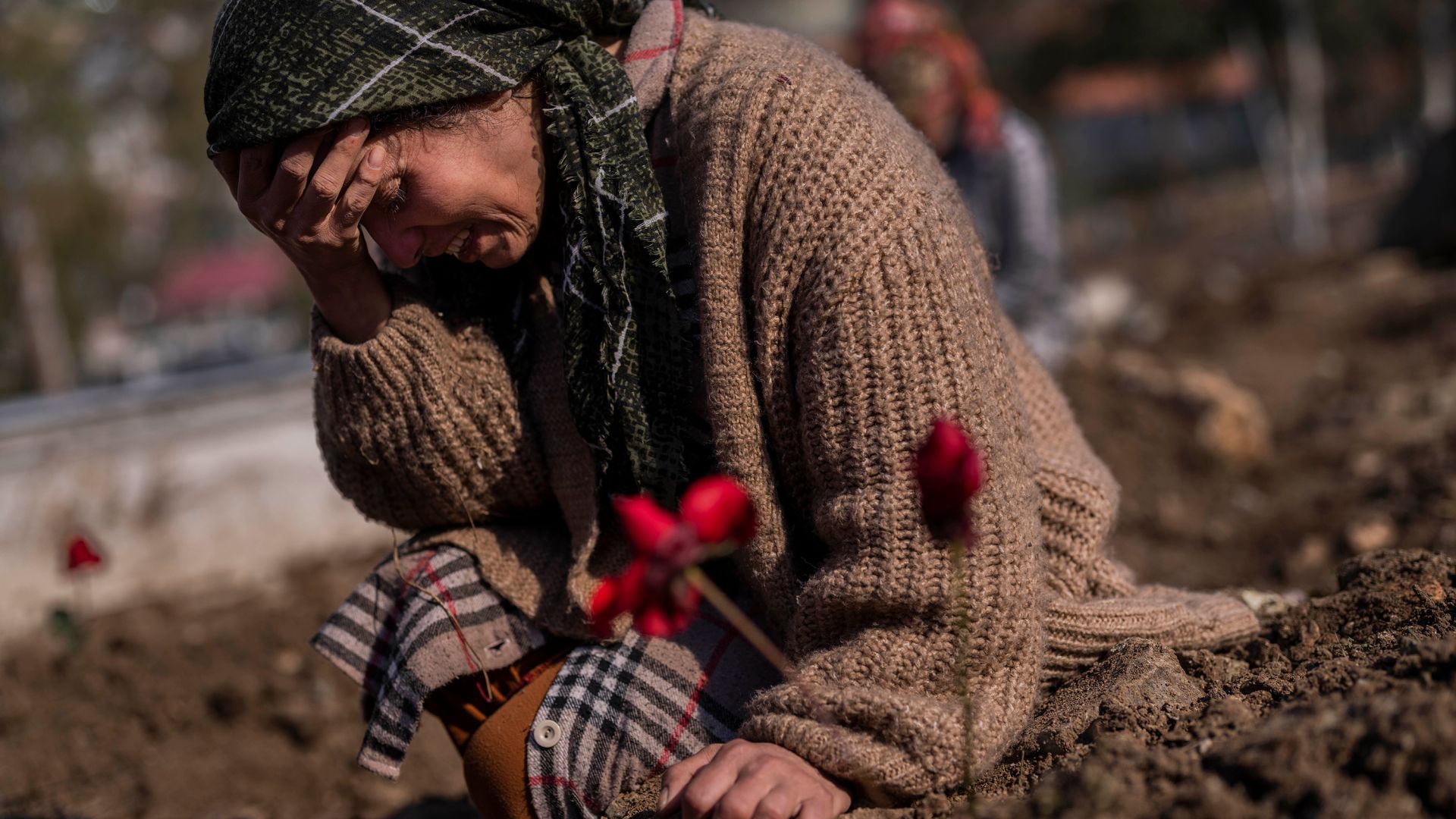 A member of the Vehibe family mourns a relative during the burial of one of the earthquake victims
