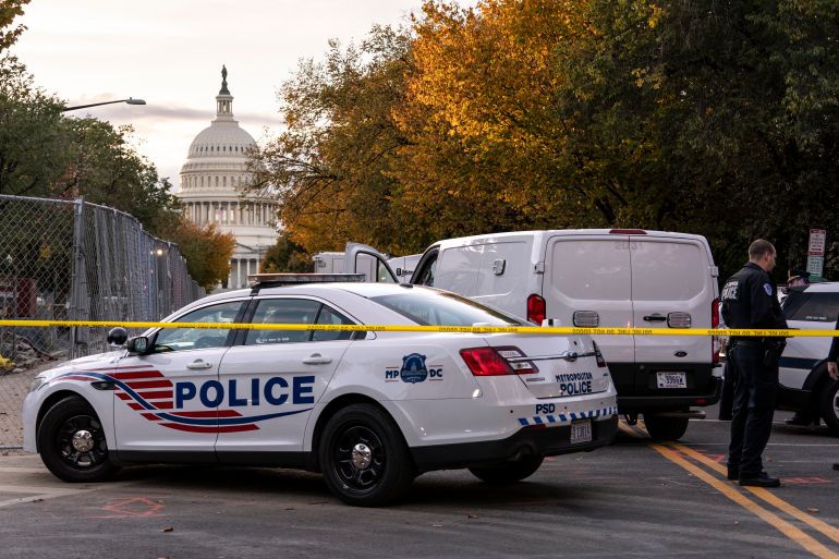 Crime scene tape surrounds police cars on a street near the US Capitol