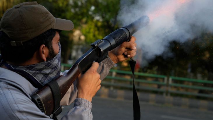 A police officer fires tear gas shell to disperse the supporters of Pakistan's former Prime Minister Imran Khan in Lahore.