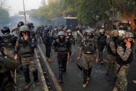 Paramilitary troops take position as riot police officer fire tear gas to disperse the supporters of former Prime Minister Imran Khan