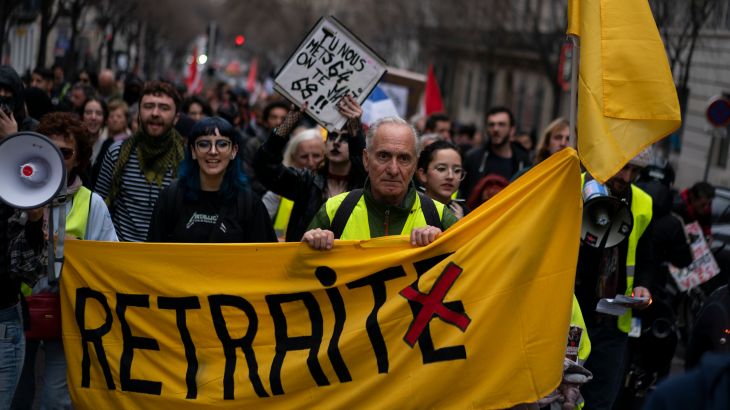 A street is filled with protesters as they march during a demonstration in Marseille, southern France, Saturday. A large banner held by people at the head of the protest reads 'Retraite' in French which translates to pension.