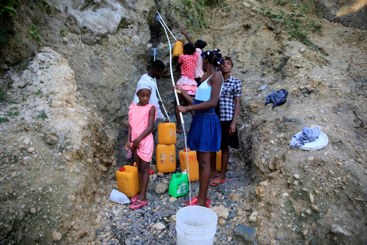 People, without running water at home, collect water from a ravine in Port-au-Prince, Haiti