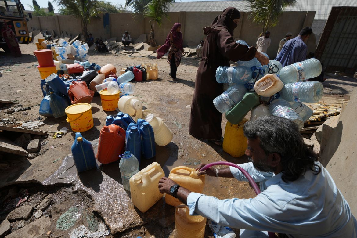People get drinking water from a water collecting point at a slum area, in Karachi, Pakistan
