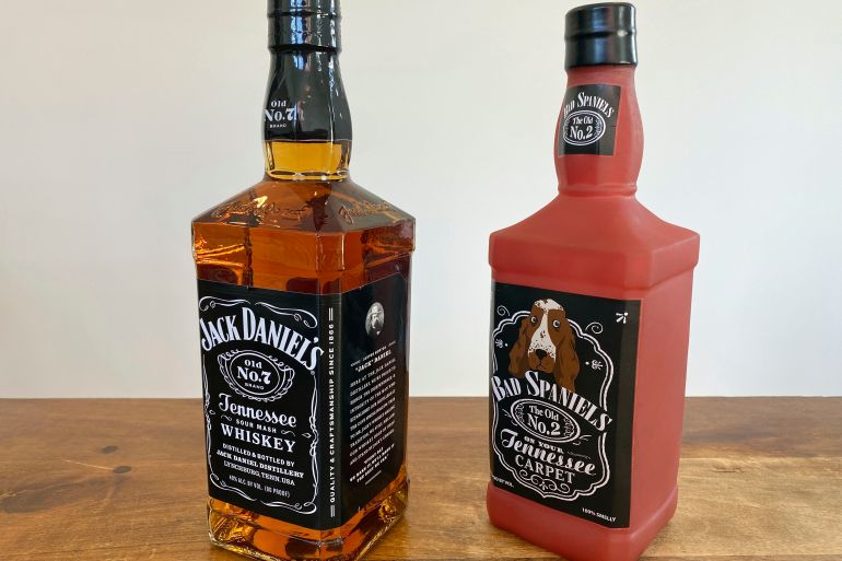 A bottle of Jack Daniels Tennessee Whiskey next to a Bad Spaniels dog toy