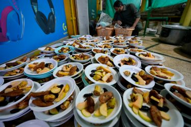 A volunteer prepares food plate to be distributed among people for breaking their fast during the Muslims holy fasting month of Ramadan, in a mosque, in Rawalpindi, Pakistan.