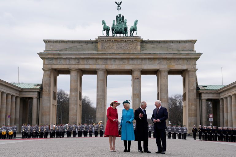German President Frank-Walter Steinmeier, right, and his wife Elke Buedenbender, left, welcome Britain's King Charles III and Camilla, the Queen Consort, in front of the Brandenburg Gate in Berlin