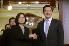 Ma Ying-jeou shaking hands with his successor Tsai Ing-wen in 2016. He is smiling.