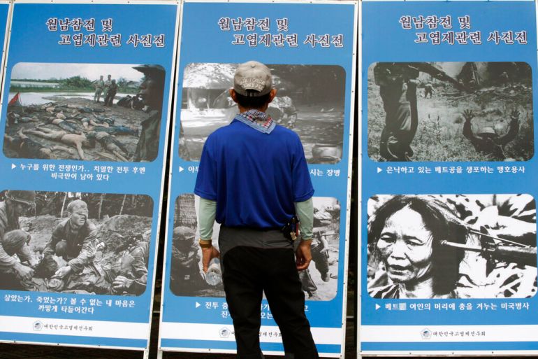 A South Korean Vietnam War veteran looks at pictures taken during the war during a rally to mark the 48th anniversary