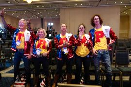 CPAC attendees pose for a photo wearing shirts that spell out "Trump"