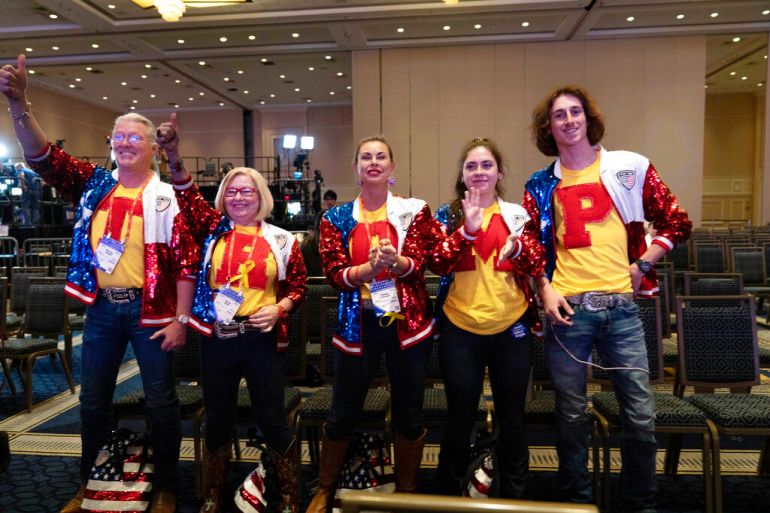 CPAC attendees pose for a photo wearing shirts that spell out "Trump"