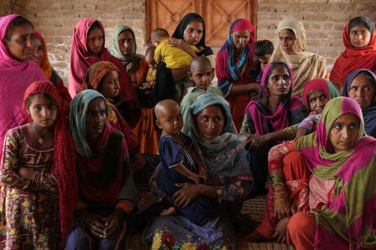 Group of women agricultural labourers gathered looks depressed