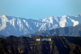Snowy mountains in the background behind the Hollywood sign in Los Angeles