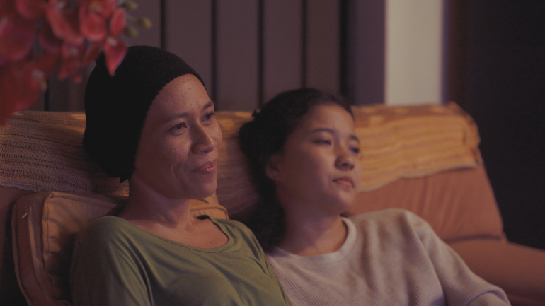 A still from the film Mentega Terbang showing mother and daughter relaxing on the sofa