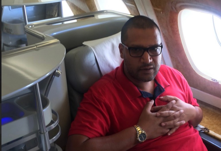 Mohamed Khan sitting in an aeroplane seat. 