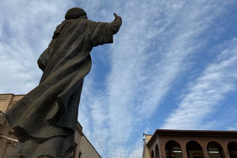 Statue in Mutannabi Street from behind, image shot from below looking up at a blue sky.