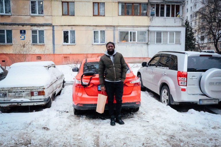 Nelson outside his apartment in a residential area situated in the hilly outskirts of Lviv, and standing in front of the Ford Sedan he travelled in to leave Ukraine