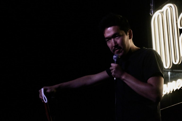 A photo of Nikita performing at a comedy club.