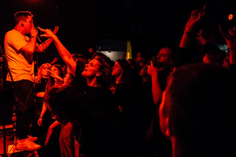 A photo of an audience watching a band perform on stage.