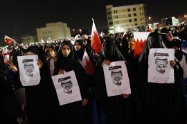 Bahraini Shia women holding pictures of a man who was allegedly killed by security forces a week before, demonstrate in an anti-government rally in the village of Muqsha, west of Manama on December 24, 2011.